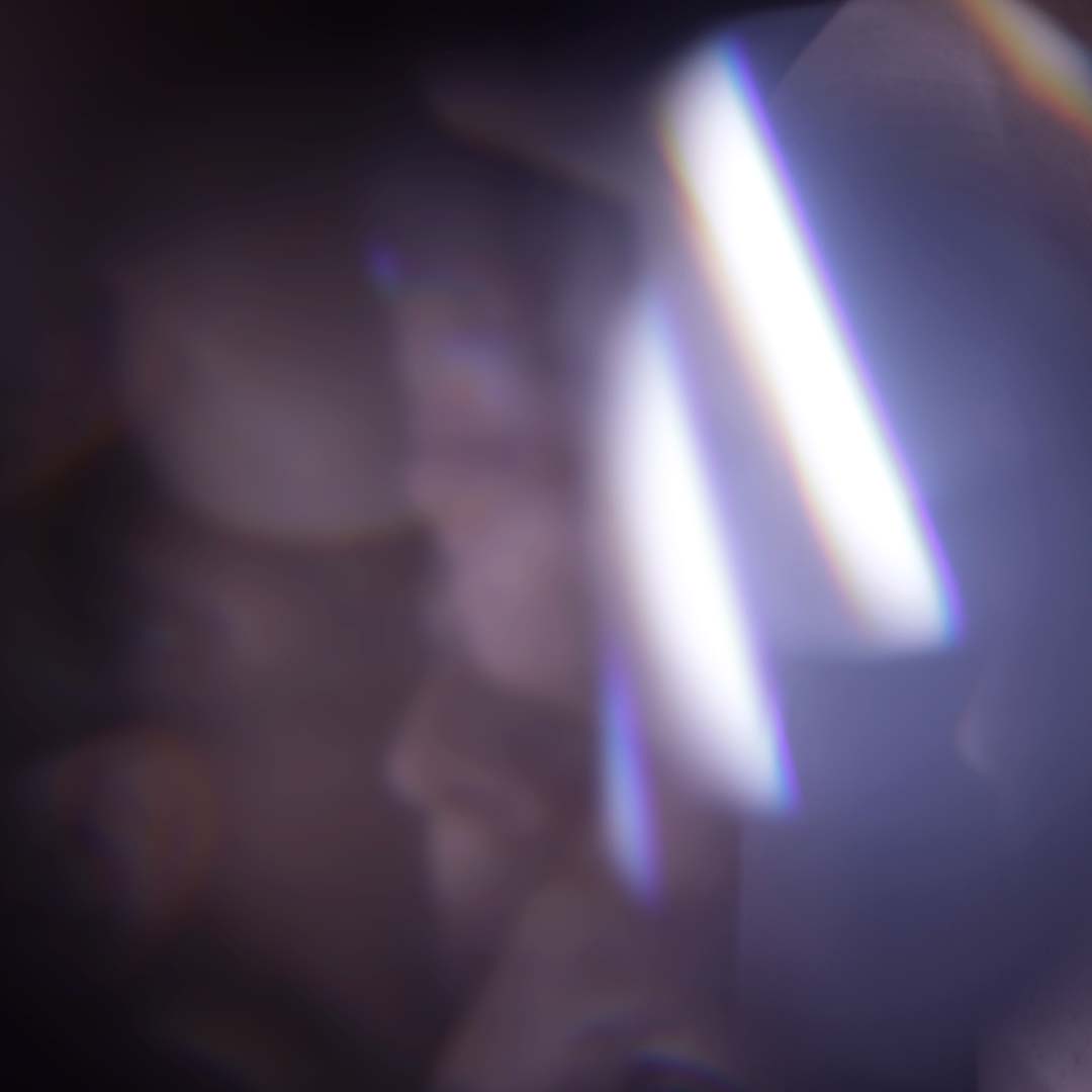 A blurry abstract image with light streaks and soft gradients of purple and blue tones.